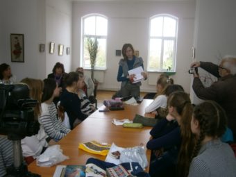 Студентка Ліля Псарук демонструє учням сумку-клатч декорований бойківською вишивкою