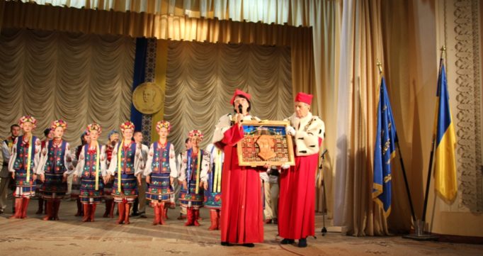 Професор Ришард Пісарські вручає вітражну картину ректору професору Надії Скотній