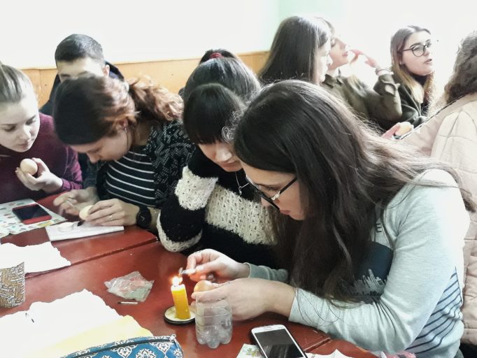 Студенти використовують техніку розпису писачком у створенні великодніх писанок.