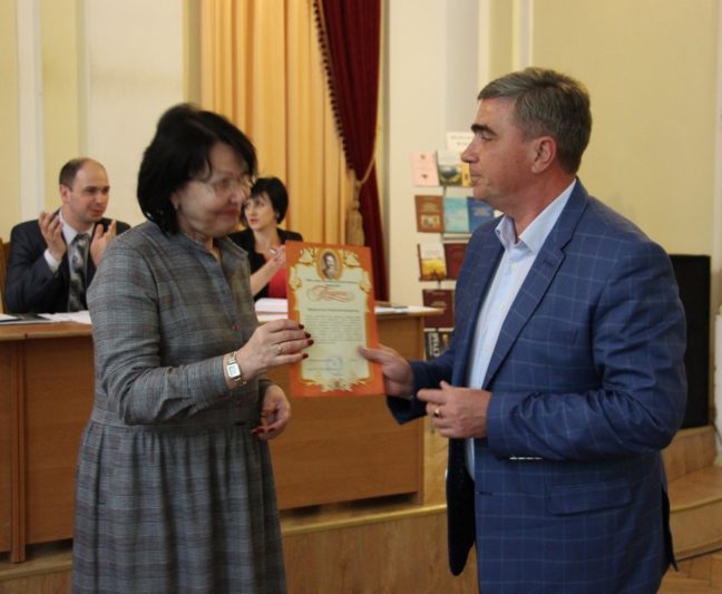 Ректор професор надія Скотна вручає відзнаку професору Леоніду Оршанському